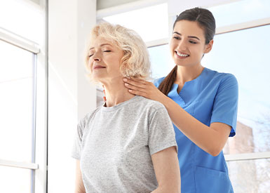 Main-service-Physiotherapy Physiotherapist supporting an older woman’s neck during an assessment